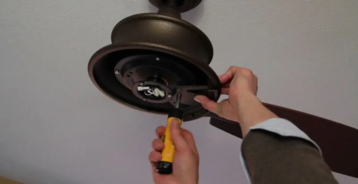 Electrician installing ceiling fan mounting bracket and fixture in Richmond, VA