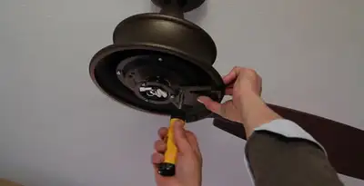 Electrician installing ceiling fan mounting bracket and fixture in Richmond, VA