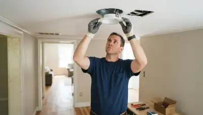 Electrician clips recessed lighting trim into a ceiling housing in a Richmond, VA home