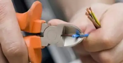 licensed electrician performing precise wire cutting and preparation during electrical service in Richmond, VA