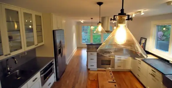 Residential electrician installing modern indoor light fixture in a home in Richmond, VA
