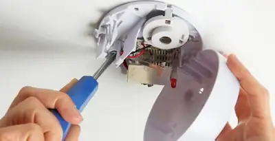Certified technician wiring smoke detector during installation in Richmond, VA